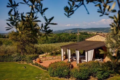 a pavilion with a table and chairs in a garden at Villa Bonazza in Marcialla