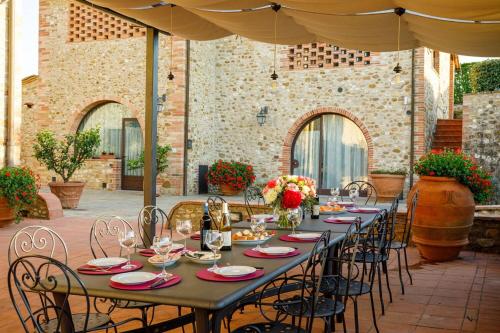 a long table on a patio with chairs at Villa Bonazza in Marcialla