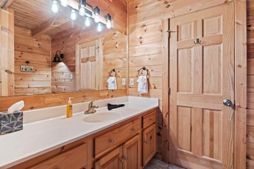 a bathroom with a sink and a mirror at SunnySierra Cabin in Sevierville