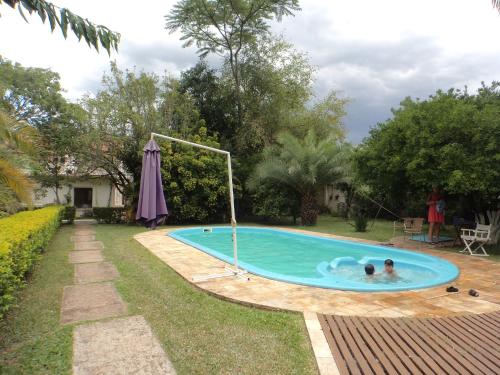 dos personas en una piscina en un patio en ROSA CORTIANA Escalera, en São Gabriel