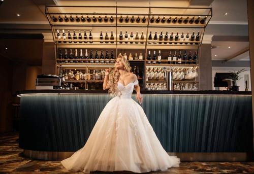 a woman in a wedding dress standing at a bar at MERCURE HOTEL KLAIPEDA CITY, Conference, Restaurant & Bar - Accor Group in Klaipėda