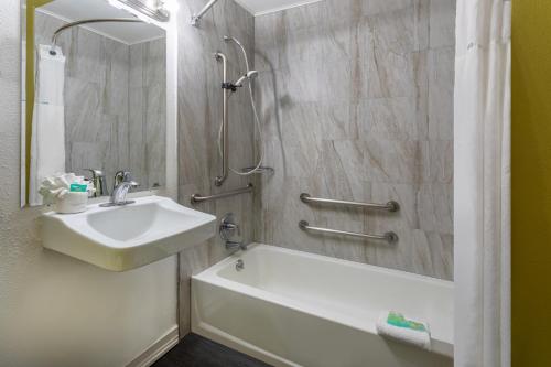a bathroom with a sink and a tub and a shower at Super 8 by Wyndham NAU/Downtown Conference Center in Flagstaff