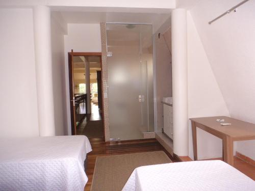 a bedroom with two beds and a door to a hallway at ROSA CORTIANA Escalera in São Gabriel