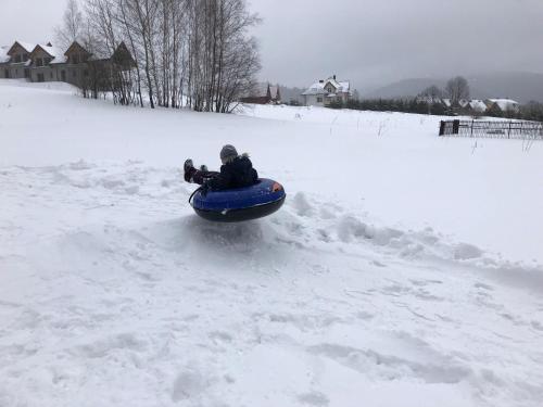 a person riding on a snowboard in the snow at Perełka Bieszczady Domki in Cisna