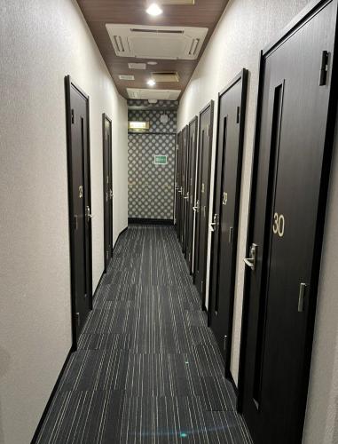 un pasillo con puertas negras y un pasillo largo en Fujiko Building 3F - Vacation STAY 35722v, en Yokosuka