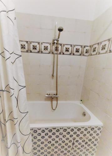 La salle de bains est pourvue d'une baignoire et d'un rideau de douche. dans l'établissement Logis des Lugats, gite de charme, à La Réole