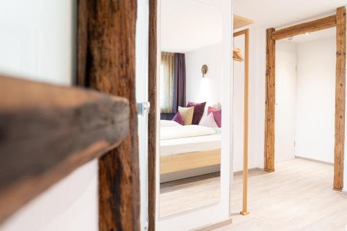 a view of a bedroom with a bed and a mirror at Hotel Restaurant Krehl's Linde in Stuttgart