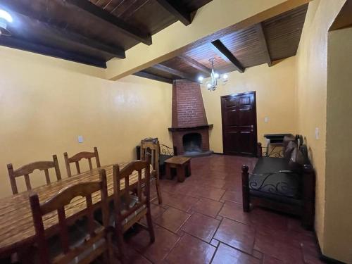 a living room with a fireplace and a table and chairs at Villas Lupita in Mazamitla