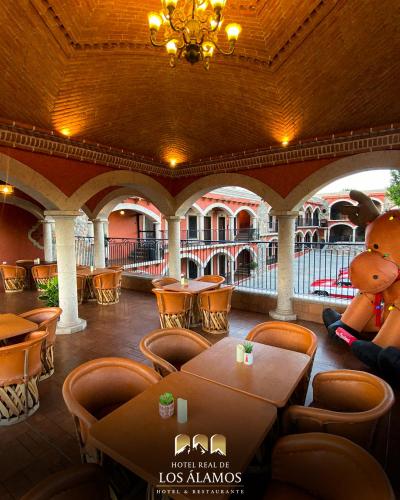 a restaurant with a teddy bear and tables and chairs at Hotel Real de los Alamos in Álamos