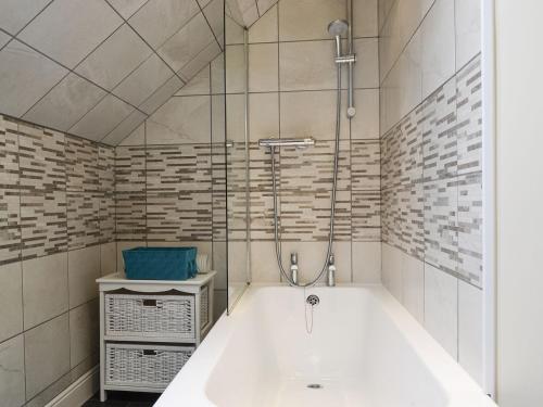 a bathroom with a bath tub and a shower at Acorn Cottage in Kingsland