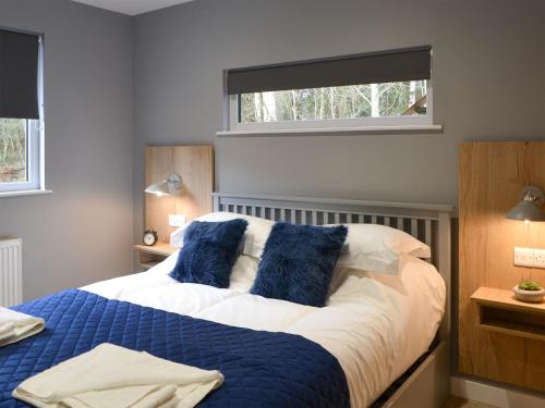 una camera da letto con un grande letto con cuscini blu di The Bunker a Otterburn