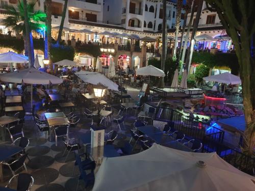 een openluchtrestaurant met tafels en parasols in de nacht bij Amazing Villamartin House Sleeps 6 with Pool in Villacosta