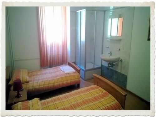a bathroom with two twin beds and a sink at Ristorante Dosso in Sigirino