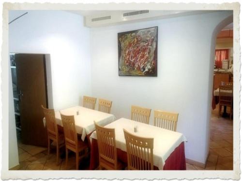 a dining room with two tables and a painting on the wall at Ristorante Dosso in Sigirino
