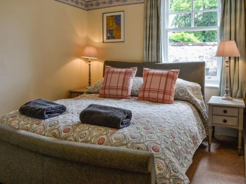 a bedroom with a bed with two pillows on it at South Lodge in Forgandenny