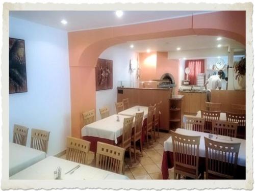 a restaurant with tables and chairs and a kitchen at Ristorante Dosso in Sigirino