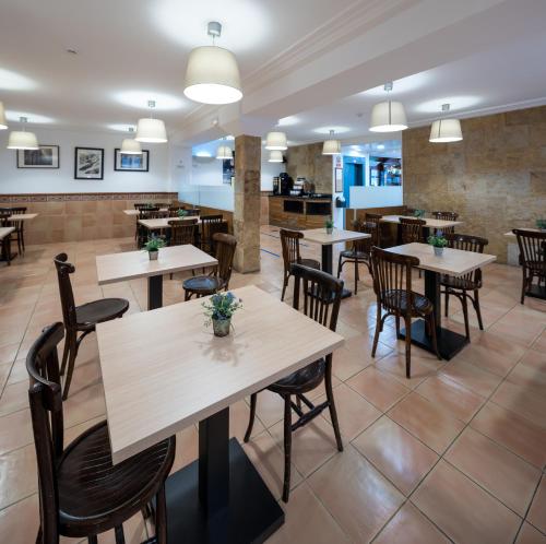 a restaurant with tables and chairs in a room at Hotel Ripoll in Sant Hilari Sacalm