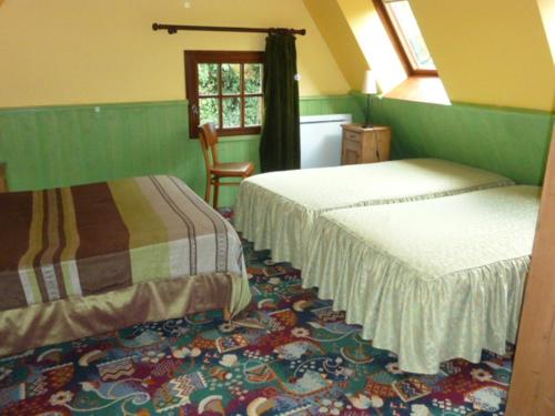 a bedroom with two beds and a chair and a window at Les Granges Du Bout De La Ville in Montville