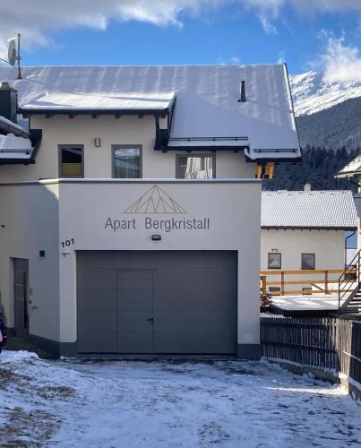 a garage in front of a house with a building at Apart Bergkristall in Nauders
