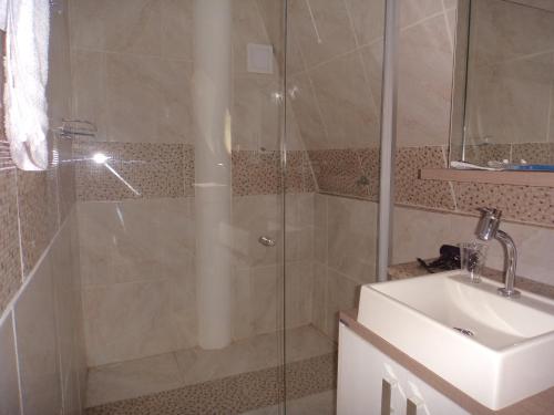 a bathroom with a shower and a sink at ROSA CORTIANA Escalera in São Gabriel
