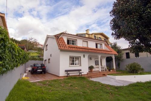 ein weißes Haus mit einer Bank im Hof in der Unterkunft Playa de Cesantes in Pontevedra