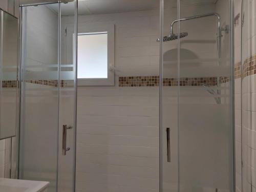 a shower with a glass door in a bathroom at Hostal GARDEN ROUS in Paiporta