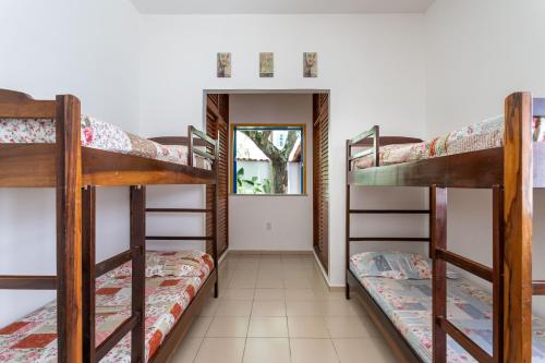 Habitación con 3 literas y pasillo. en Casa Praia do Forte, en Cabo Frío