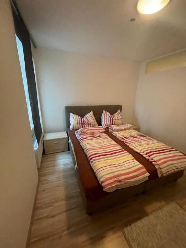 a small bedroom with a bed with striped sheets at City Appartement 4910 in Ried im Innkreis