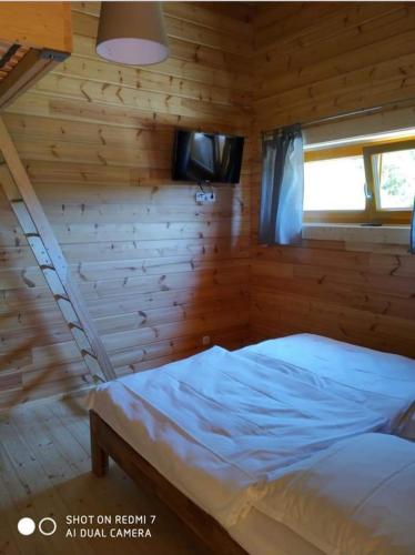 a bedroom with a bed in a wooden cabin at Felsenlandblick in Dahn
