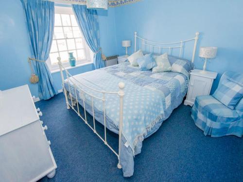 ブレイクニーにあるDelphinium Cottage - Ukc2843の青いベッドルーム(ベッド1台、椅子付)