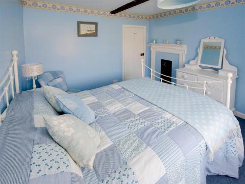 ブレイクニーにあるDelphinium Cottage - Ukc2843の青いベッドルーム(ベッド1台、鏡付)