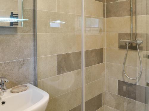 a bathroom with a shower and a sink at Hafod Y Bryn in Benllech