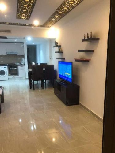 a living room with a television and a dining room at Marina city port ghalib chalet in Port Ghalib