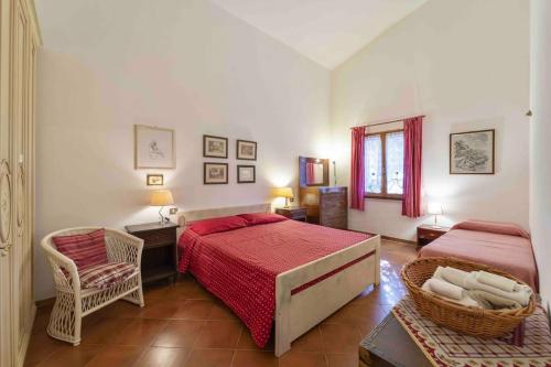a bedroom with two beds and a chair at Casa Montjuïc Mare & Passione in Alghero