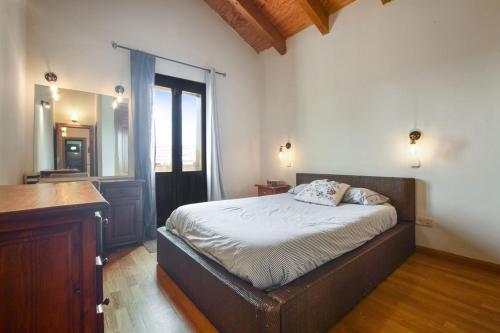 a bedroom with a bed and a dresser and a mirror at Chalet Navacerrada Piscina Privada in Navacerrada