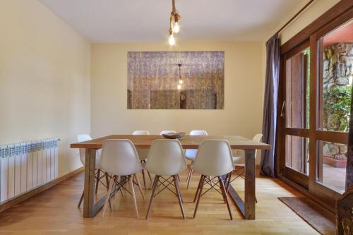 a dining room with a wooden table and chairs at Chalet Navacerrada Piscina Privada in Navacerrada