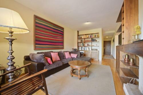a living room with a couch and a table at Chalet Navacerrada Piscina Privada in Navacerrada