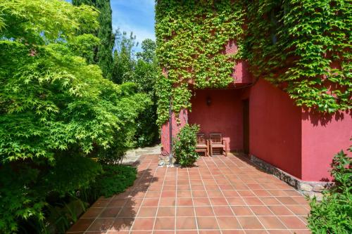 a red building with a patio with two chairs at Chalet Navacerrada Piscina Privada in Navacerrada