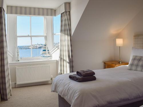 a bedroom with a bed and a large window at Harbourside Apartment in Anstruther