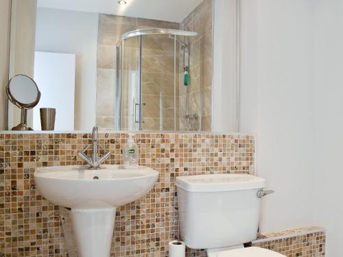 a bathroom with a toilet and a sink and a shower at Harbourside Apartment in Anstruther