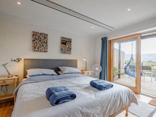 a bedroom with a large bed with towels on it at Jack Strawbale House - Uk7521 in Strontian