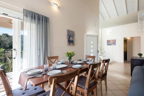 a dining room with a wooden table and chairs at Kassiopi Central House in Kassiopi