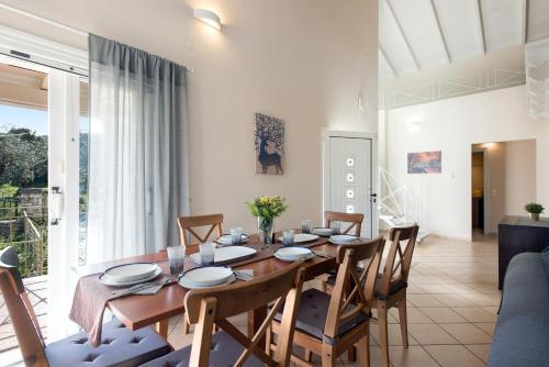 Un comedor con mesa y sillas de madera. en Kassiopi Central House, en Kassiopi