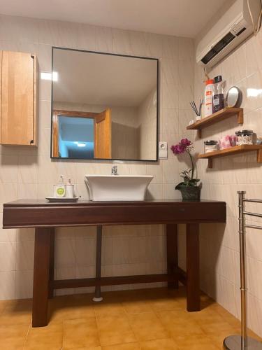 W łazience znajduje się umywalka i lustro. w obiekcie Apartamentos EL PELIGRO w mieście Archidona