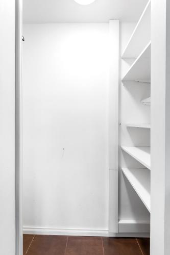 an open door to a closet with white shelves at WeHost Heart of Helsinki Studio with Top Amenities in Helsinki