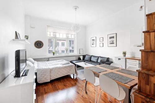 a living room with a table and a couch at WeHost Heart of Helsinki Studio with Top Amenities in Helsinki