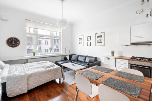 a kitchen and living room with a table and a couch at WeHost Heart of Helsinki Studio with Top Amenities in Helsinki