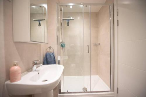 a bathroom with a shower and a sink and a sink at Number 15 Luxurious Two Bedroom Apartment in Exmouth