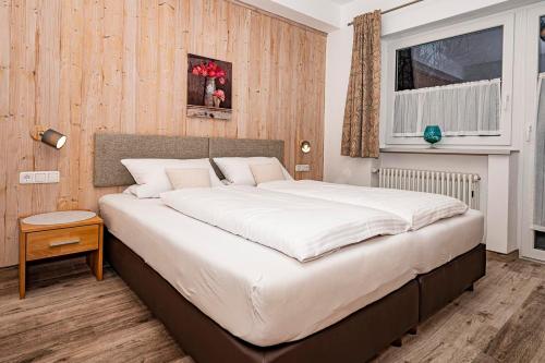 1 dormitorio con 1 cama blanca grande en una habitación en Ferienwohnung Kircher, en Obermaiselstein