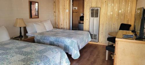 a hotel room with two beds and a television at Bishop Village Motel in Bishop